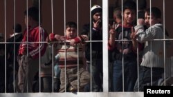 Syrians who fled Syria stand behind the gate of a refugee camp near the Turkish-Syrian border in the southeastern city of Yayladagi. (file photo)