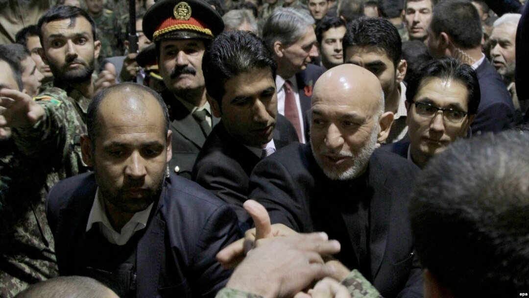 Afghan President Hamid Karzai (right) shakes hands with the Afghan soldiers during the ceremony opening the National Army Officer Academy outside Kabul on November 11..
