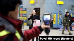 A Kazakh worker uses a thermal scanner to detect travelers who may have symptoms possibly connected with coronavirus at Almaty International Airport.