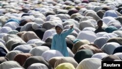 A boy stands amidst Muslims performing the Eid al-Adha prayer in Karachi on September 25. 