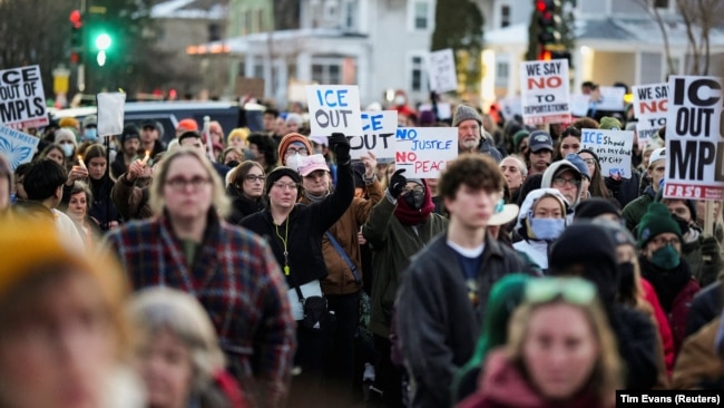 Люди тримають плакати, беручи участь у жалобній церемонії, Міннеаполіс, 7 січня 2026 року