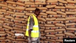 A World Food Program worker walks past bags of relief food at a distribution center at a refugee camp near the Kenyan-Somali border in August.