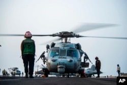 MH-60S Seahawk helikopterbe száll be a legénység a USS Ronald Reagan fedélzetén, 2021. július 30-án.