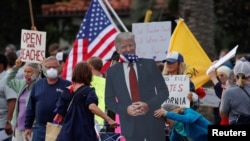 Дональд Трамп в маске, сделанный из картона в знак протеста против закрытия пляжей и пешеходных дорожек во время вспышки COVID-19. Калифорния, 19 апреля 2020 года.