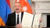 U.S. - Azerbaijan President Ilham Aliyev holds a signed trilateral declaratoin during a ceremony with Armenian Prime Minister Nikol Pashinian and President Donald Trump at the White House, Washington, August 8, 2025.