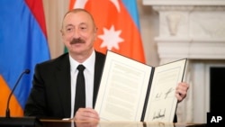 U.S. - Azerbaijan President Ilham Aliyev holds a signed trilateral declaratoin during a ceremony with Armenian Prime Minister Nikol Pashinian and President Donald Trump at the White House, Washington, August 8, 2025.