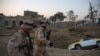 Croatian soldiers from the NATO coalition are walking past a crater from a bomb blast as they inspect the site of an attack targeting the German consulate in Mazar-e Sharif on November 11.