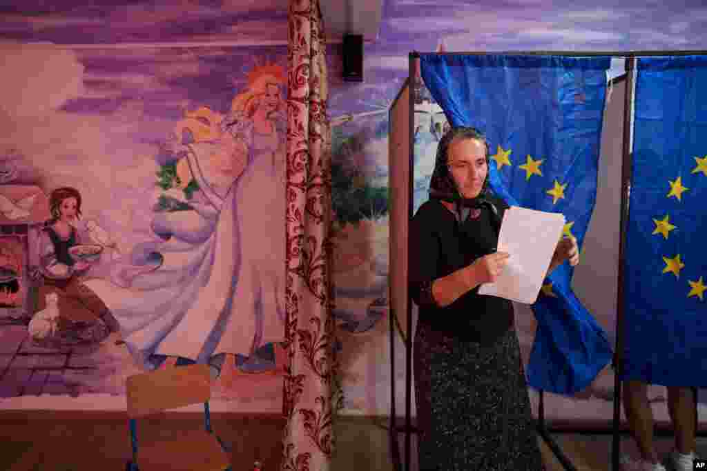 O femeie iese dintr-o cabină de vot după ce și-a exprimat opțiunea politică la alegerile europene și locale din Băleni, județul Dâmbovița, 9 iunie 2024.