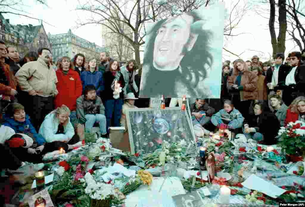 Люди собрались на &laquo;Strawberry Fields&raquo; в Центральном парке в десятую годовщину со дня убийства Джона Леннона, 8 декабря 1990 года.&nbsp;На заднем плане&nbsp;&ndash; многоквартирный дом &laquo;Дакота&raquo;, где Леннон жил со своей семьей