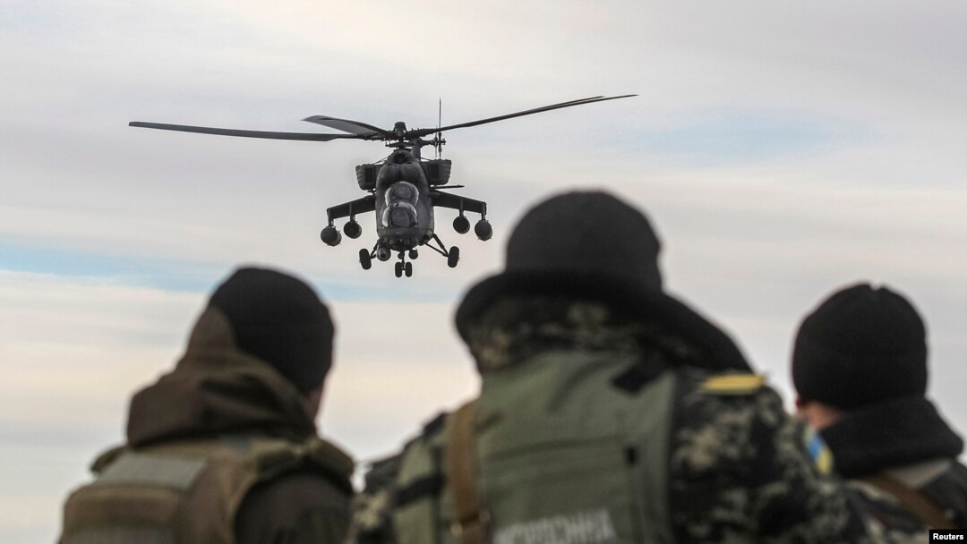 A Russian army chopper patrols the area as Ukrainian servicemen guard a checkpoint near the village of Strelkovo in the Kherson region adjacent to Crimea. Ironically many of the engines used by Russia's military helicopters are made in Ukraine. 