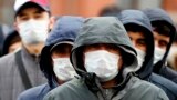 Migrant workers wearing protective face masks line up outside a migration control center to prolong their stay in Russia amid the ongoing coronavirus pandemic in St. Petersburg on April 3.