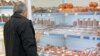 Armenia -- A man looks at meat products at a food store in Yerevan.