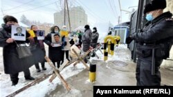 Sinjiangda dereksiz ýitenleriň ýa-da gözenegiň aňrysyna atylanlaryň hossarlary Almaty şäherindäki Hytaý konsulhanasynyň öňünde piket geçirýärler. 2021-nji ýylyň 10-njy fewraly.