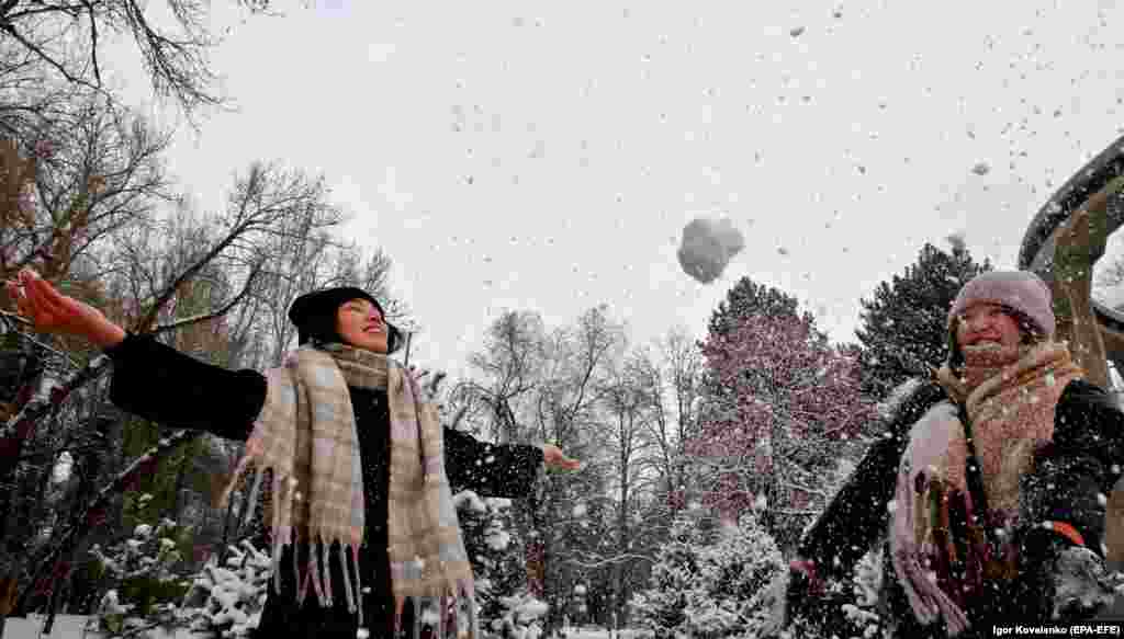 People enjoy a heavy snowfall in the Kyrgyz capital, Bishkek, on February 25. (epa-EFE/Igor Kovalenko)