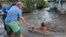 Two men work to save a resident who was swept away by floodwaters in Galati, Romania, on September 14. 