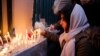 A mourner in Tehran lights candles for those who died in a Ukrainian passenger plane when it was shot down over the Iranian capital in January 2020. 