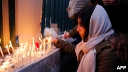 A mourner in Tehran lights candles for those who died in a Ukrainian passenger plane when it was shot down over the Iranian capital in January 2020. 