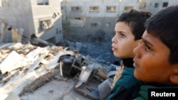 Fëmijët palestinezë e vështrojnë dëmin në shtëpitë e bombarduara nga Izraeli në Kan Jounis, në jug të Rripit të Gazës, 10 dhjetor 2023.