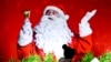 INDIA -- Christian devotees stand beside a poster of Santa Claus at the Sacred Heart Cathedral Church, on the eve of Christmas Day celebrations, in New Delhi on December 24, 2024