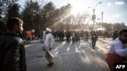 Emberek távoznak a helyszínről a dél-iráni Kermán városában, ahol két robbanás történt Kászem Szolejmáni tábornok 2020-as meggyilkolásának évfordulóján, 2024. január 3-án