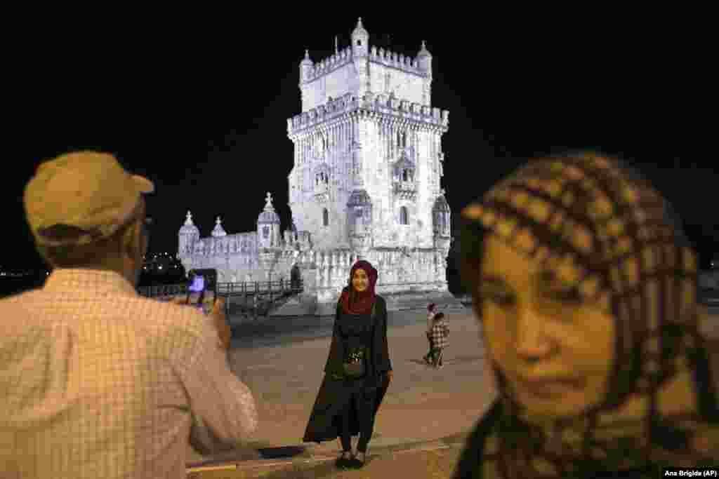 A member of the Afghan girls&#39; national soccer team poses for her father in front of the Belem Tower at a park by the Tagus River in Lisbon on September 29.
