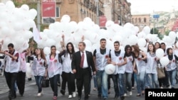 Armenia - A senior member of the ruling Republican Party escorts young party activists to an election campaign rally in Yerevan's Republic Square, 4May2012.