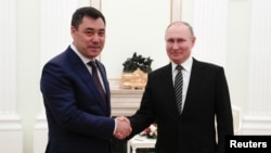 Kyrgyzstan's Sadyr Japarov (left) skaes hands with Russia's Vladimir Putin in Moscow
on February 24.