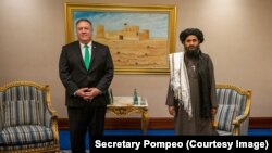 Američki državni sekretar Mike Pompeo i mula Abdul Gani Baradar, suosnivač talibana i bivši zamjenik mule Omara. Baradar, koji je godine proveo u pakistanskom zatvoru, politički je šef talibana i bio je glavni pregovarač u razgovorima sa Sjedinjenim Državama. 