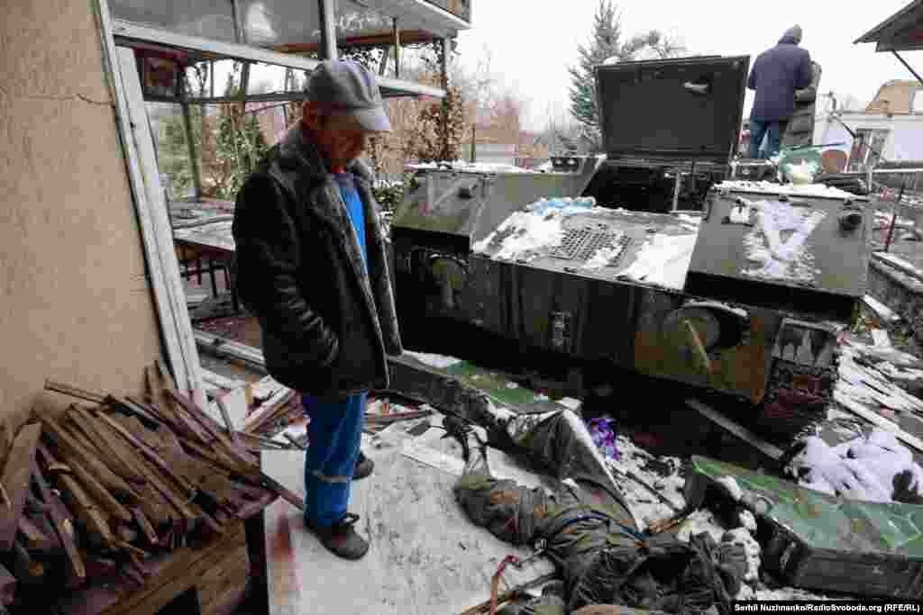 Чоловік дивиться на тіло російського солдата, що лежить біля БМД (бойова машина десанту), Буча, Київська область, 1 березня 2022 року