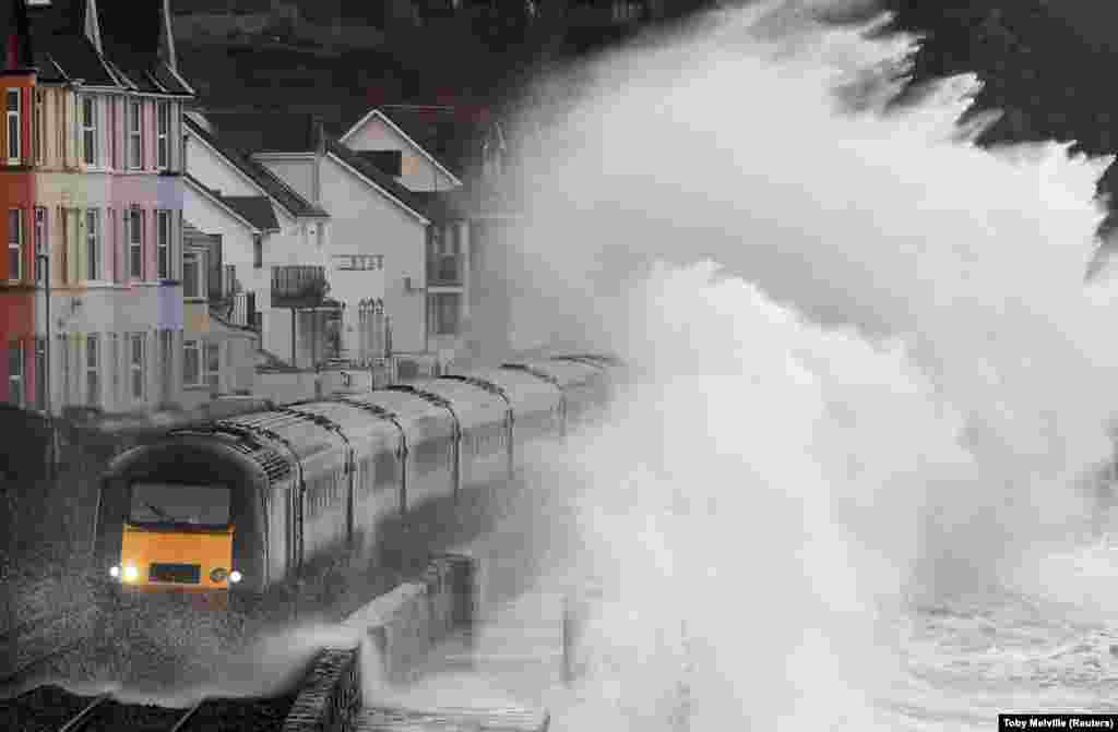 Large waves crash over a train as it passes through Dawlish in southwest Britain. (Reuters/Toby Melville)