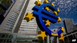 Sculptura înfățișând simbolul monedei europene unice în fața sediului Băncii centrale europene de la Frankfurt.