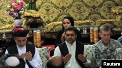 Afghan President Hamid Karzai (left) prays at a meeting with tribal leaders in Kandahar city on June 13. "I want your cooperation in this operation," he said.