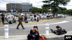 Utasok várakoznak a toulouse-i repülőtér előtt október 18-án a terminál terrorveszéllyel összefüggő kiürítése miatt. Fotó: Charly Triballeau / AFP