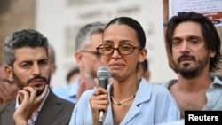 Yossra Fakir, nepoata lui Abderrahim Fakir, citește o declarație la mitingul de protest.