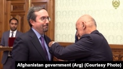 FILE: Afghan President Ashraf Ghani conferred an Afghan medal on outgoing U.S. Ambassador John Bass (L) on December 31, 2019.
