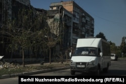 Маршрутка проїжджає повз пошкодженого внаслідок російського удару будинку, Покровськ, вересень 2024 року