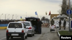 Cars lined up to pass a checkpoint, erected by ethnic Tatars and members of Ukrainian nationalist battalions, outside the settlement of Chonhar, which borders with the territory of Crimea, November 23, 2015. 