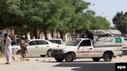 Pakistani security officials inspect the area from where two Chinese nationals were abducted by unknown armed men in Quetta on May 24.