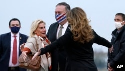 U.S. Secretary of State Mike Pompeo (center), and his wife, Susan (right), embrace U.S. Ambassador to France Jamie McCourt (left) after stepping off a plane in Paris on November 14.