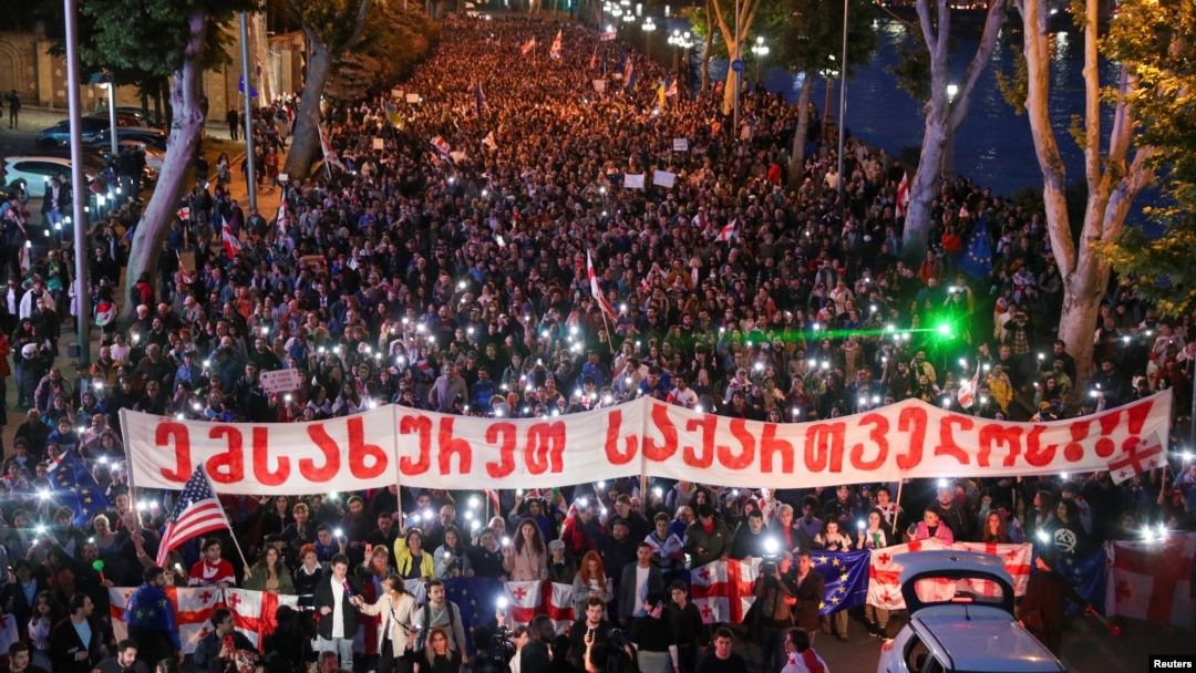Demonstrators march against the "foreign agent" bill and to support Georgia's membership in the European Union in Tbilisi on May 24, with a banner reading "Serve Georgia."