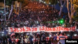 Demonstrators march against the "foreign agent" bill and to support Georgia's membership in the European Union in Tbilisi on May 24, with a banner reading "Serve Georgia."