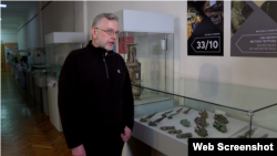 Сергей Диденко возле витрины с экспонатами крымской археологии в Национальном музее истории Украины
