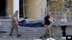 Police officers carry the body of a victim of a Russian strike in Kyiv on June 1.