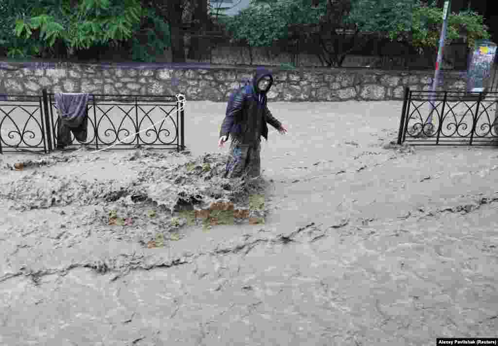 Чоловік стоїть по коліно у воді на одній із затоплених вулиць Ялти