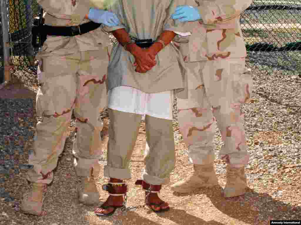 Guards escort a detainee to a medical facility at Guantanamo Bay.