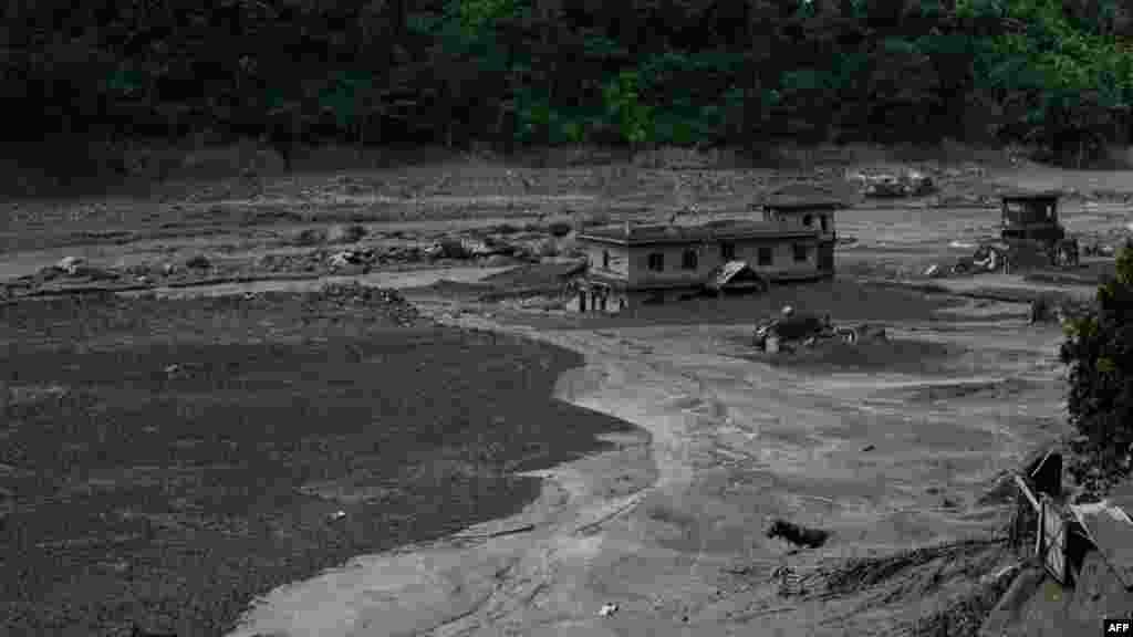 Fotografija snimljena 26. avgusta prikazuje kuću delimično zatrpanu muljem nakon bujičnih poplava u Trišuli Bazaru u Nepalu. Američki geološki institut (USGS) saopštio da potres, za koji se prvobitno verovalo da je imao magnitudu 4,4, zapravo predstavlja seizmičku energiju nastalu usled urušavanja stena i leda, nakon čega je usledio veliki tok nanosa.