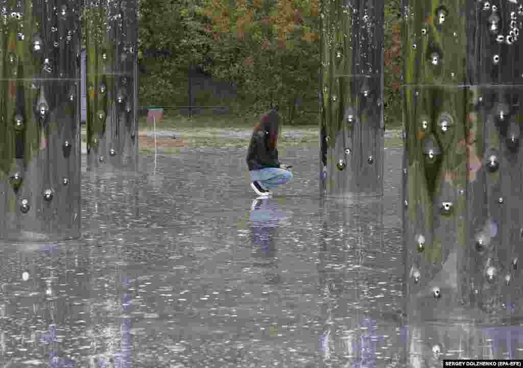 A girl visits the audiovisual installation Mirror Field with symbolic Trees of Life before a prayer in memory of the victims of the Holocaust on the eve of the Jewish religious holiday Yom Kippur at Babyn Yar in Kyiv.