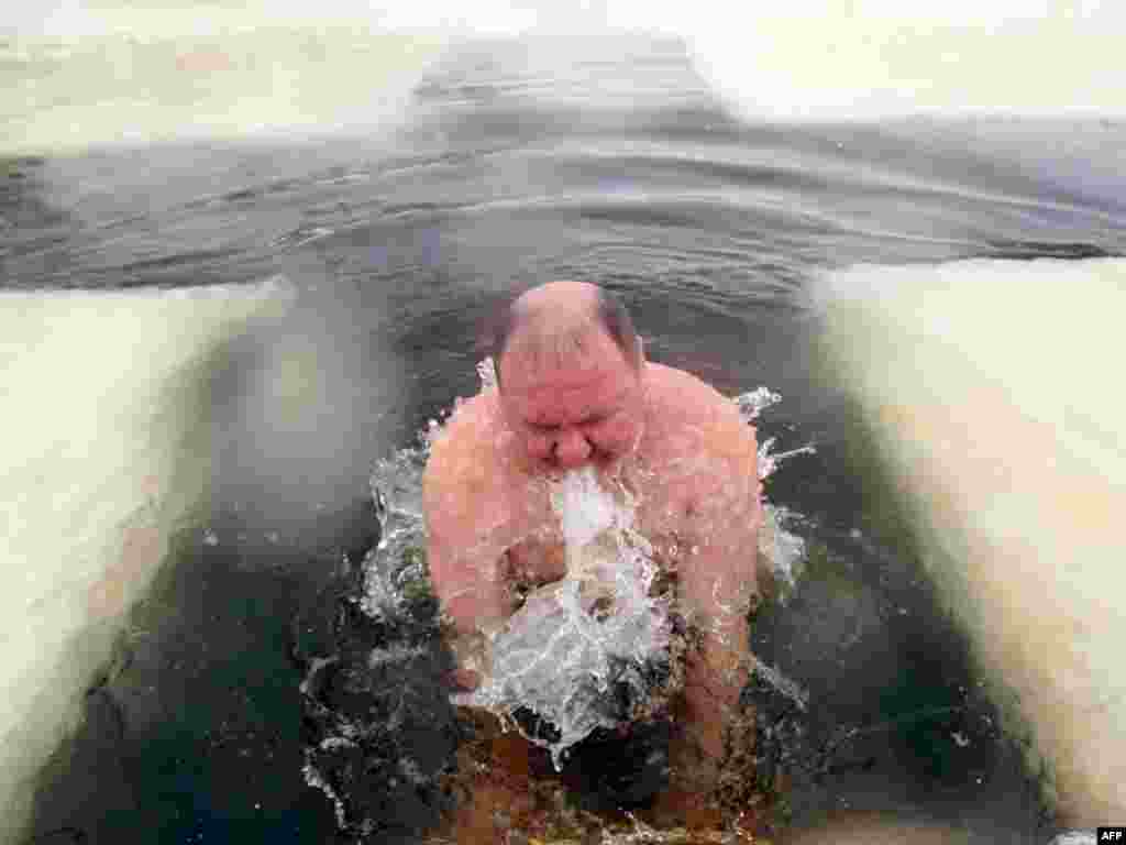 A Russian Orthodox believer plunges into icy waters in celebration of the Epiphany holiday in Kolpino, close to St. Petersburg, on January 19. Thousands of Russians jumped into holes cut in ice, braving freezing temperatures, on January 18 and early on January 19 to mark the Epiphany, when Russian Orthodox believers take part in a baptism ceremony. Photo by Kirill Kudryavtsev for AFP 