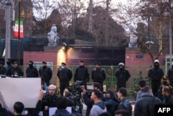 Iranian police stand guard in front of the UK Embassy in Tehran during a protest by members of the Basij volunteer Islamic militia on January 14, the same day a funeral ceremony was held for scores of members of Iranian security forces killed in the recent demonstrations