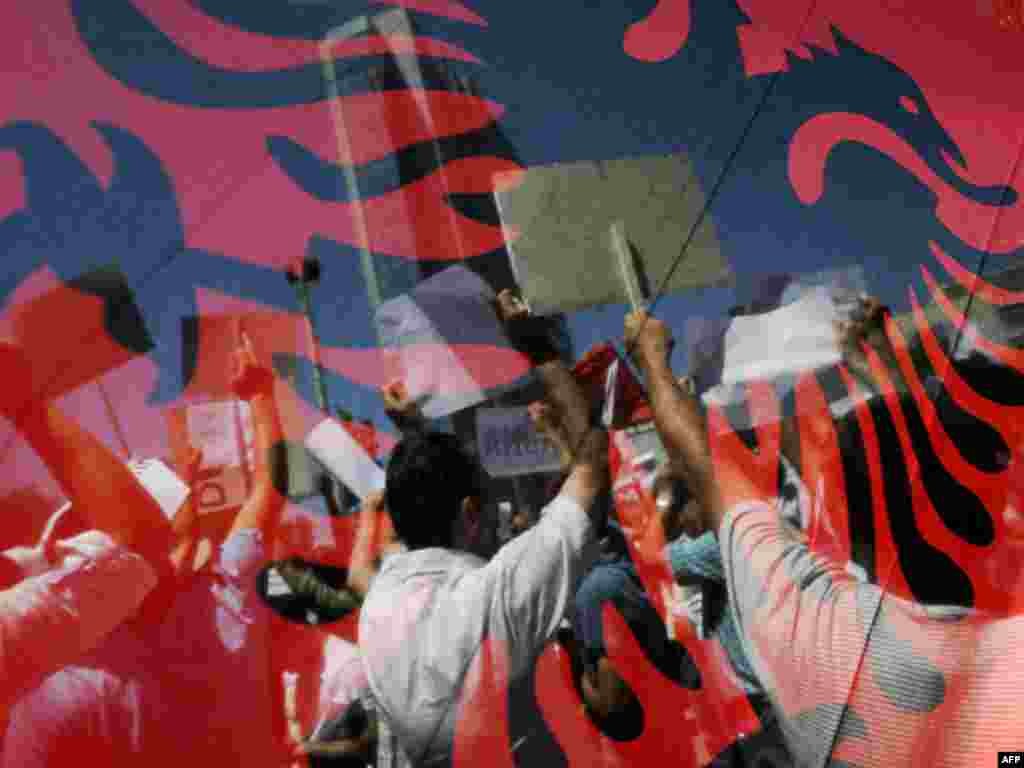 Kosovo Albanian men are seen through Albanian flags as they shout slogans during a protest in Pristina on June 22. Thousands of Kosovars turned out to demonstrate against widespread government corruption in the first significant social movement since Kosovo declared independence.Photo by Armend Nimani for AFP PHOTO